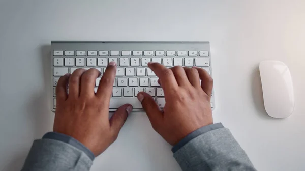 Its going to be an evening dedicated to emails. High angle shot of an unrecognizable businessman sitting alone in the office and typing on a keyboard