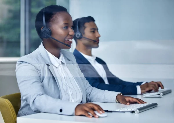 Helping customers one call at a time. two young call center agents working at their desks in the office