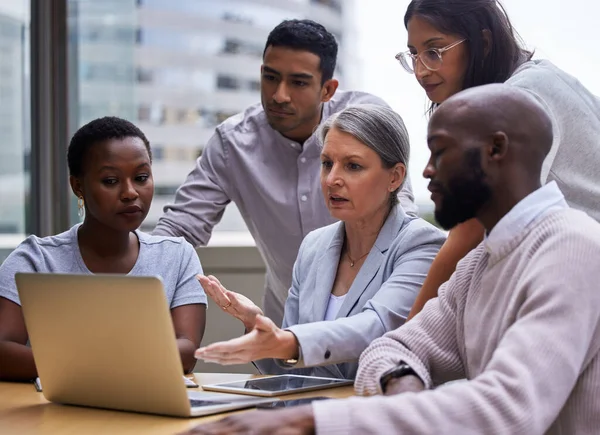 Chase the vision, not the money. a group of professional coworkers using a laptop together at work