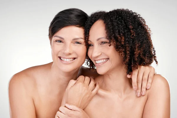 Natural beauty will always be best. two beautiful mature women posing against a grey background in studio