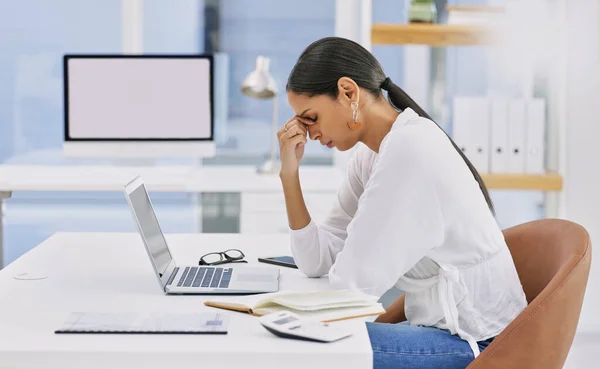 What pains me gets you your thrill. a young businesswoman sitting at a desk suffering a migraine in a modern office