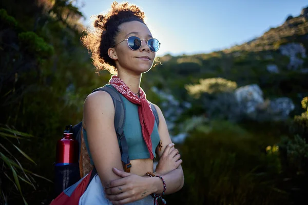 Im just in time for sunset. a young woman wearing her sunglasses while out on a hike