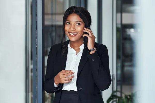 Hello, this is your future calling and its looking good. a young businesswoman using a smartphone in a modern office