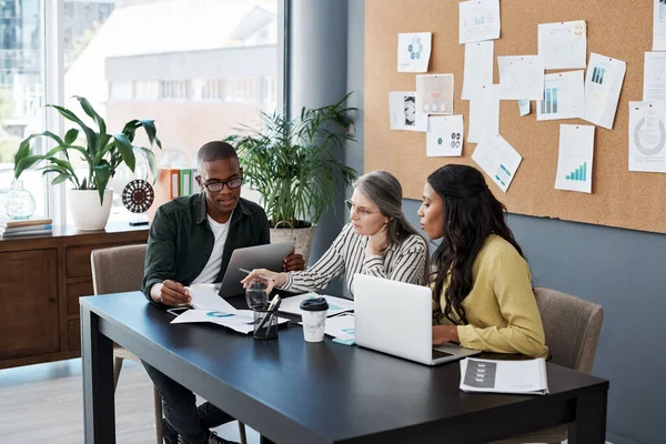 Im peepin at your people different. a group of businesspeople brainstorming and using a laptop in a modern office