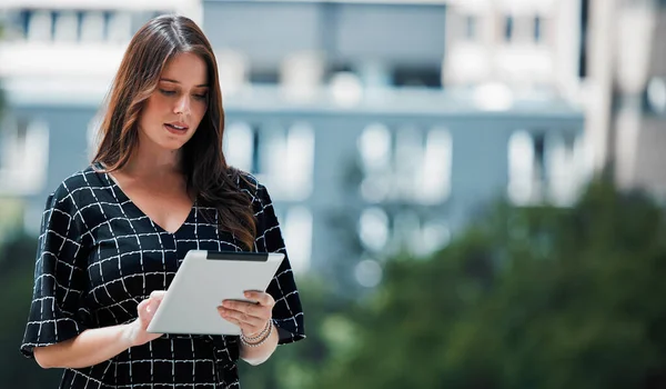 Fresh air brings fresh ideas. a young businesswoman using a tablet against an urban background