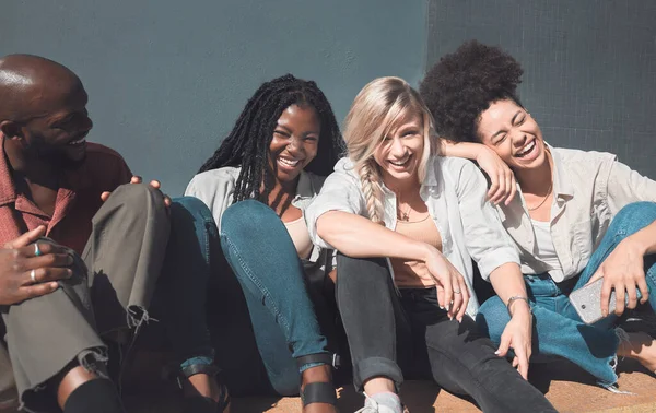 Happy, trendy and carefree friends laughing, talking and having fun enjoying their free time together outside. Diverse group bonding, hangout out and relaxing while catching up on the weekend.