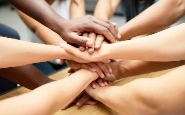 Were stronger as a team. a diverse team of staff piling their hands together