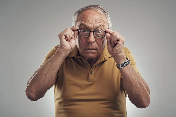 Studio Shot Elderly Man Adjusting His Spectacles Grey Background — Zdjęcie stockowe