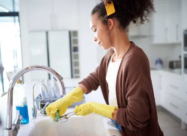 Because a dirty kitchen is a dirty house. a young woman washing the dishes at home