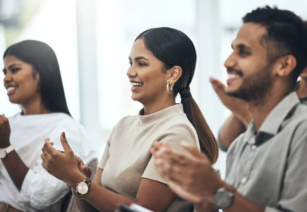 This is what a healthy work environment looks like. a group of people clapping and smiling during a meeting at work