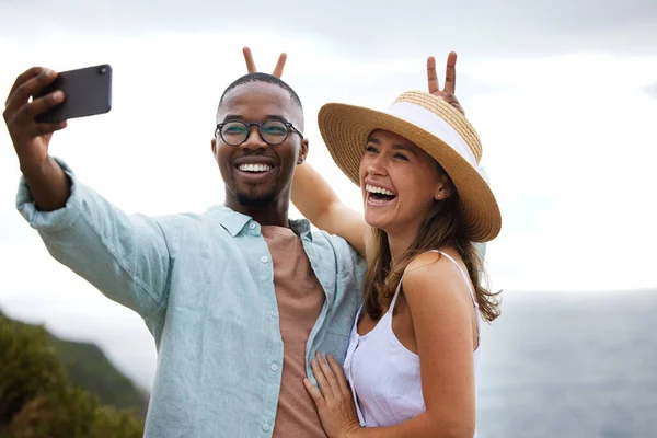 Make the good times last a long time. a happy young couple taking selfies on a road trip along the coast