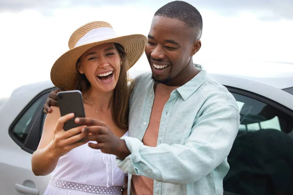 Travel gives you memories money could never buy. a happy young couple taking selfies on a road trip