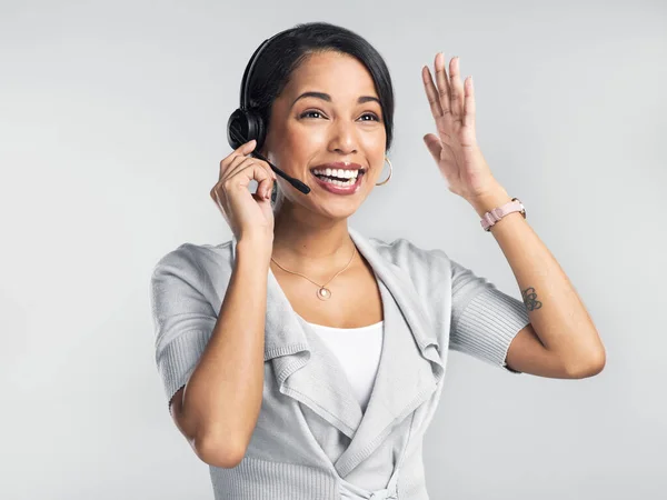 Customer service so good it defies all logic. Studio shot of a confident young businesswoman using a headset against a grey background