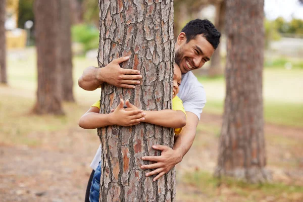 Body of the world, there is soul, you are that. a young man and a boy hugging a tree in the woods
