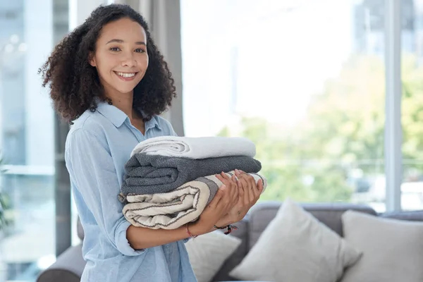 Neatly folded clean laundry is so satisfying. a young woman holding a pile of clean folded laundry