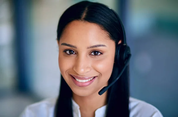 Ready for your call when you are. a young woman using a headset in a modern office