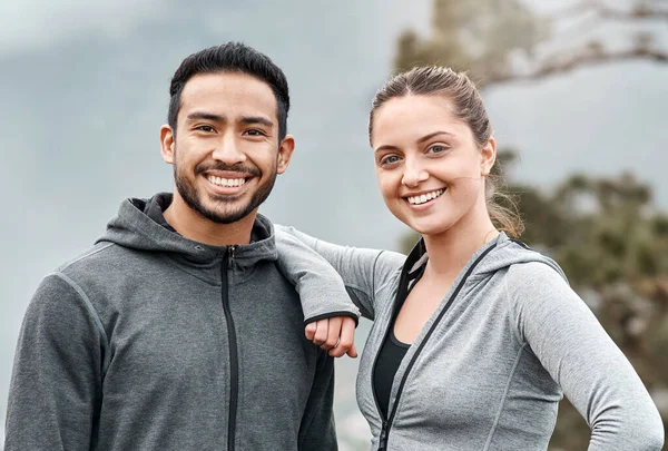 We regularly hit the trails together. Portrait of a sporty young man and woman exercising outdoors