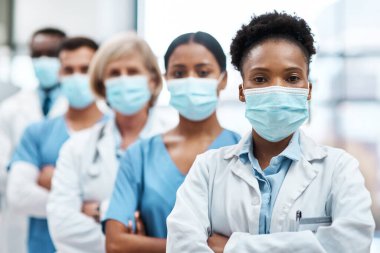 The heroes on the front lines of the pandemic. Portrait of a group of medical practitioners wearing face masks while standing together in a hospital