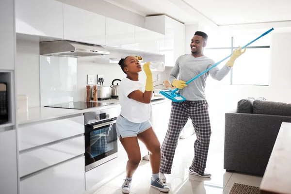 Nothing makes a marriage sparkle like good, clean fun. a happy young couple having fun while cleaning the kitchen at home
