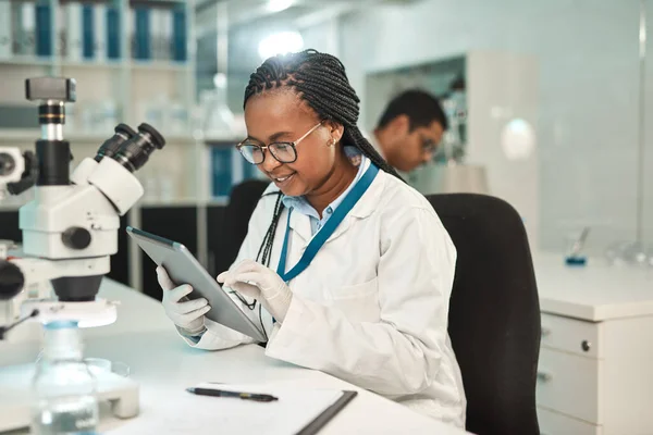 Organising new scientific data. a young scientist using a digital tablet in a lab