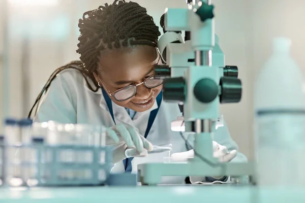 Science is a vital channel of knowledge. a young scientist using a microscope in a lab
