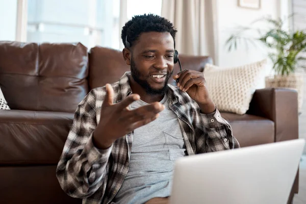 I can help you with that. a young man wearing a headset while working on a laptop at home