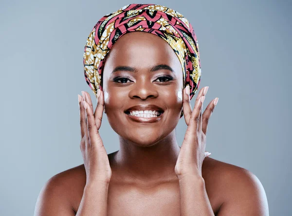 I choose to love myself. Studio portrait of a beautiful young woman applying face lotion against a grey background