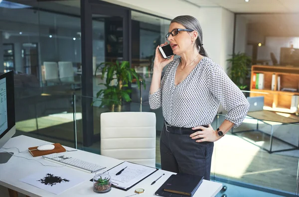 Cant talk in person She does phone consultations too. a confident mature psychologist using a smartphone in a modern office