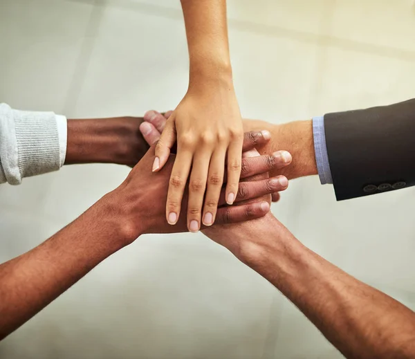 Hands of business people stacked together in group for unity, teamwork and motivation. Team of office workers, employees and colleagues piling and stacking hands for support, trust and victory.