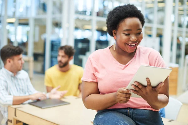 The best technology to keep her team aligned. a young businesswoman using a digital tablet during a team meeting in a modern office