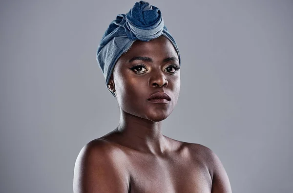 The world needs your magic. a beautiful young woman wearing a denim head wrap while posing against a grey background