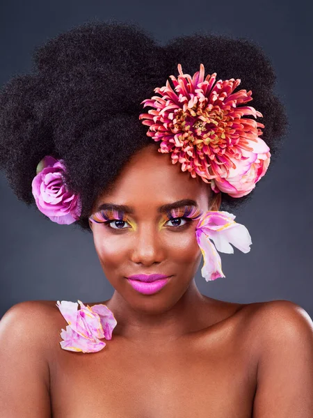 A pop of colour makes all the difference. Studio shot of a beautiful young woman posing with flowers in her hair