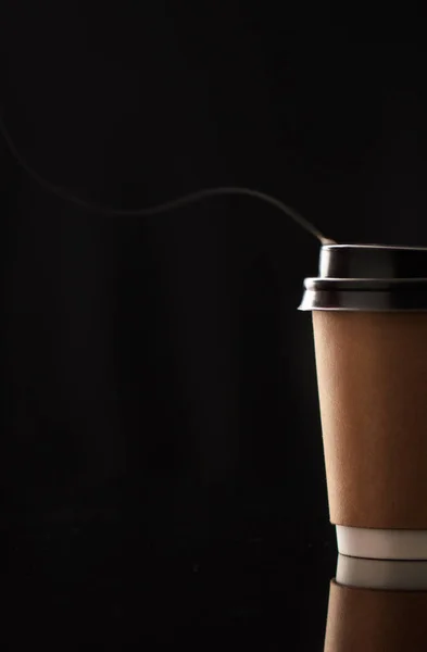 Grab a cup to go. Closeup shot of steam rising from a paper cup filled with a warm beverage