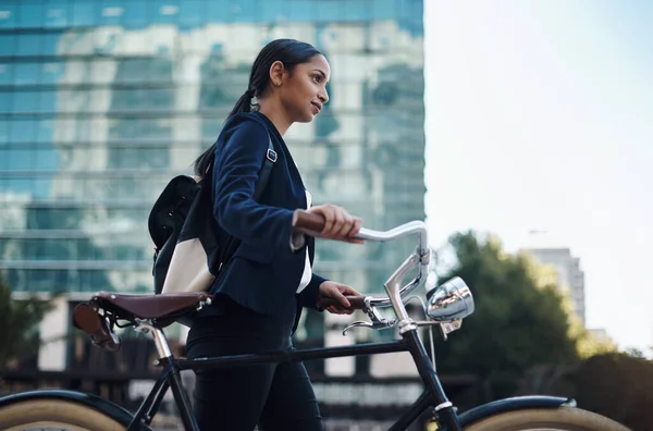 Keep going and youll get there. a young businesswoman traveling with a bicycle through the city