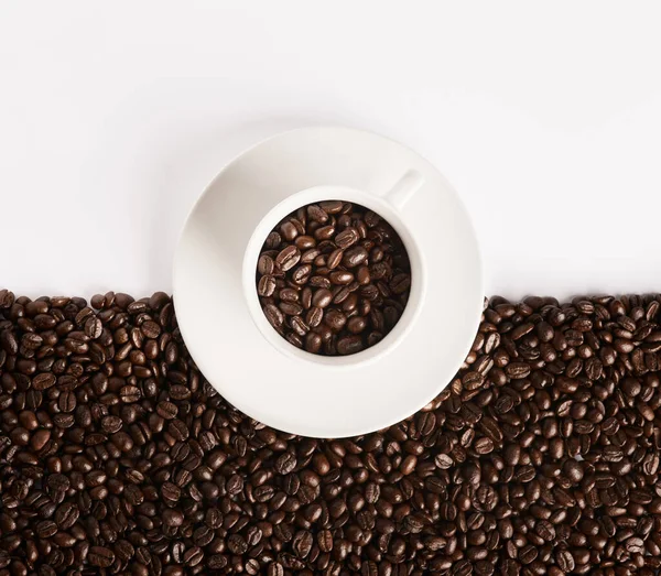 Life would be boring without coffee. Closeup shot of a cup filled with coffee beans against a half-and-half background