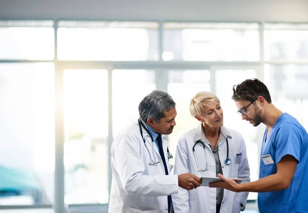 Medical Professional Team Workers Holding Tablet Talking Solving Problem Together — Zdjęcie stockowe