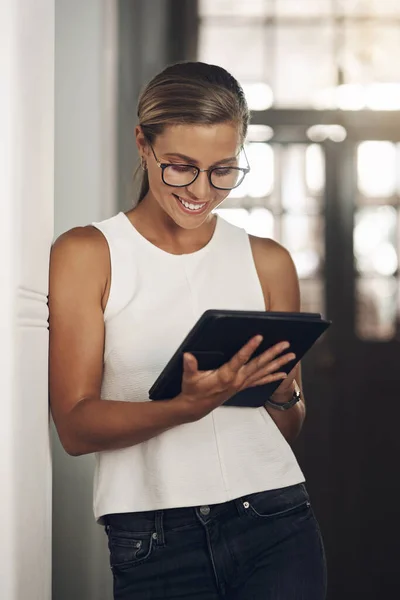 For a streamlined workday use smart apps. a young businesswoman using a digital tablet in a modern office