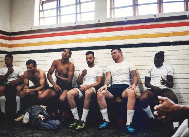 Theyre here because of their love for the sport. a group of handsome young rugby players sitting together in a locker room during the day