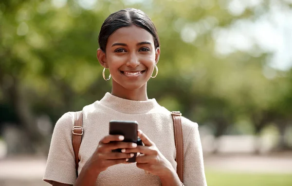 The best task management app for an entrepreneur like me. a young businesswoman using a smartphone against a city background