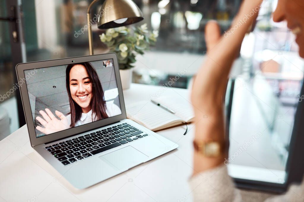 Digital collaborations done with ease across departments and locations. a young woman waving while appearing on a laptop screen during a video call