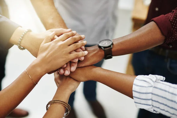 Business people hands stacked showing unity, teamwork and collaboration gesture for a project goal at a team meeting. Group closeup of corporate workers joining, working together and standing united.