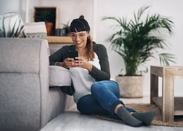 This is such a funny video. Full length shot of an attractive young woman sitting in her living room alone and using her cellphone