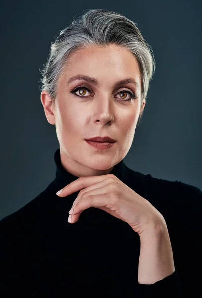 Ive never seen elegance go out of style. Studio portrait of a beautiful mature woman posing against a dark background