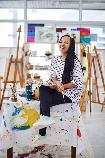 I feel more alive when Im creating. a beautiful young woman smiling at the camera in a art studio