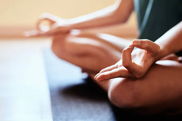 Be totally present in this moment. a woman meditating in the lotus position during a yoga session