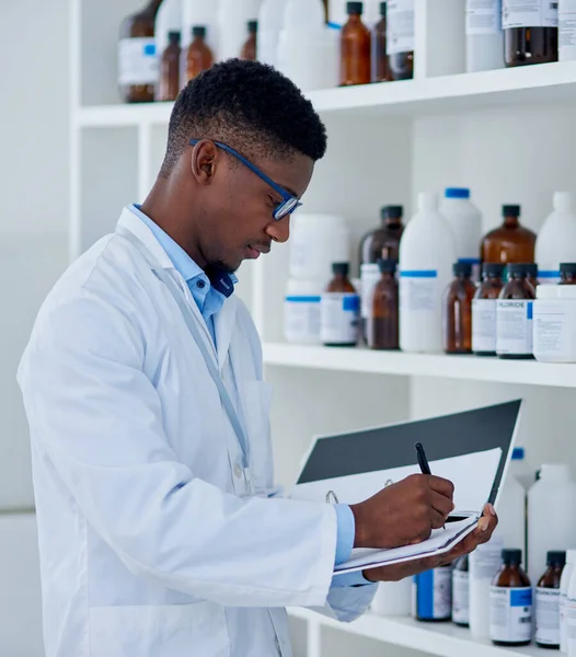 Theres a few things we need to stock up on. a focused young male scientist making notes while taking while doing stock on supplies inside of a laboratory during the day