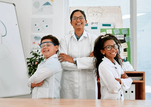 We came to learn and have lots of fun. Portrait of a confident little boy and girl standing together with their teacher in science class at school