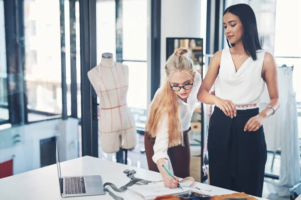 Dont worry, Ill make sure it fits you like a glove. a successful young fashion designer in her workshop