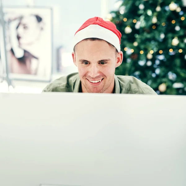 Someone is feeling a little jolly at work today. a handsome young businessman working in his office on Christmas Eve