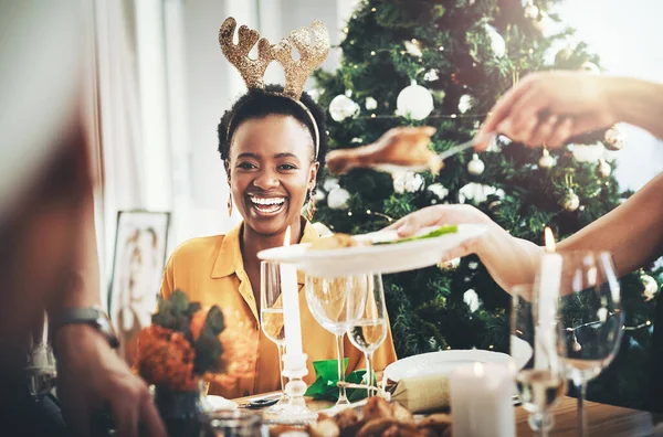 Christmases lunches are my favourite thing ever. an attractive young woman smiling while having Christmas lunch with her friends at home